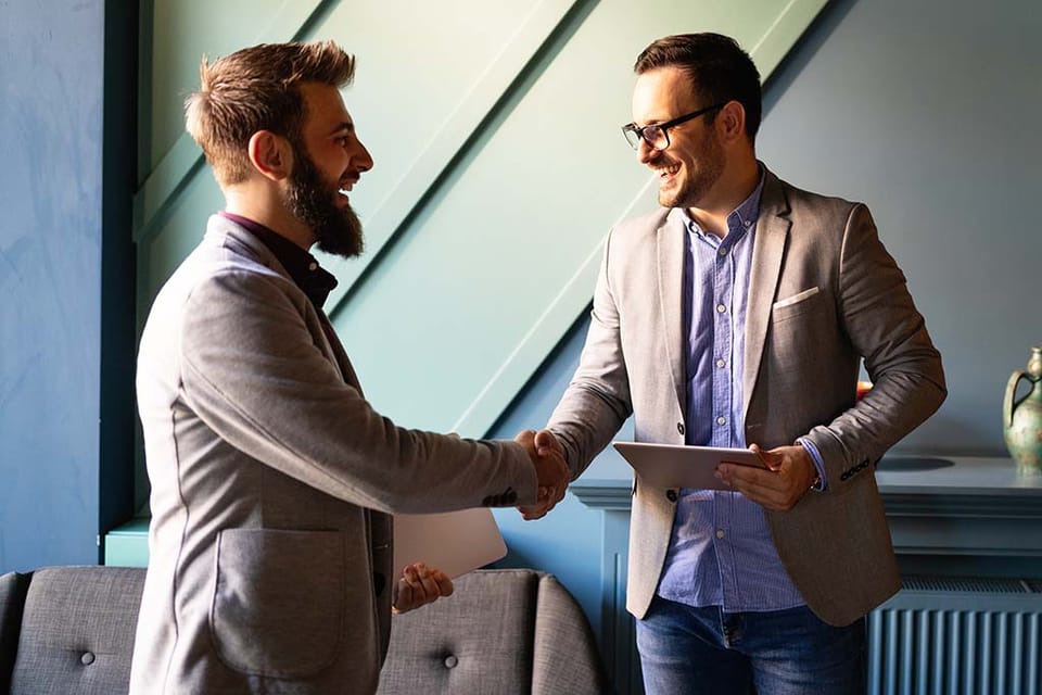 IT consultant closing a deal with a new client in utah with a handshake and smile